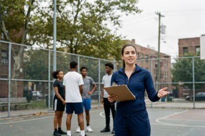 Animatrice sportive encadrant un groupe de jeunes sur un terrain de basketball en plein air